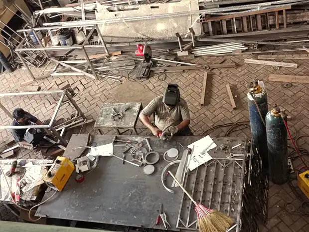 Welders fabricating metal frames in the metal shop